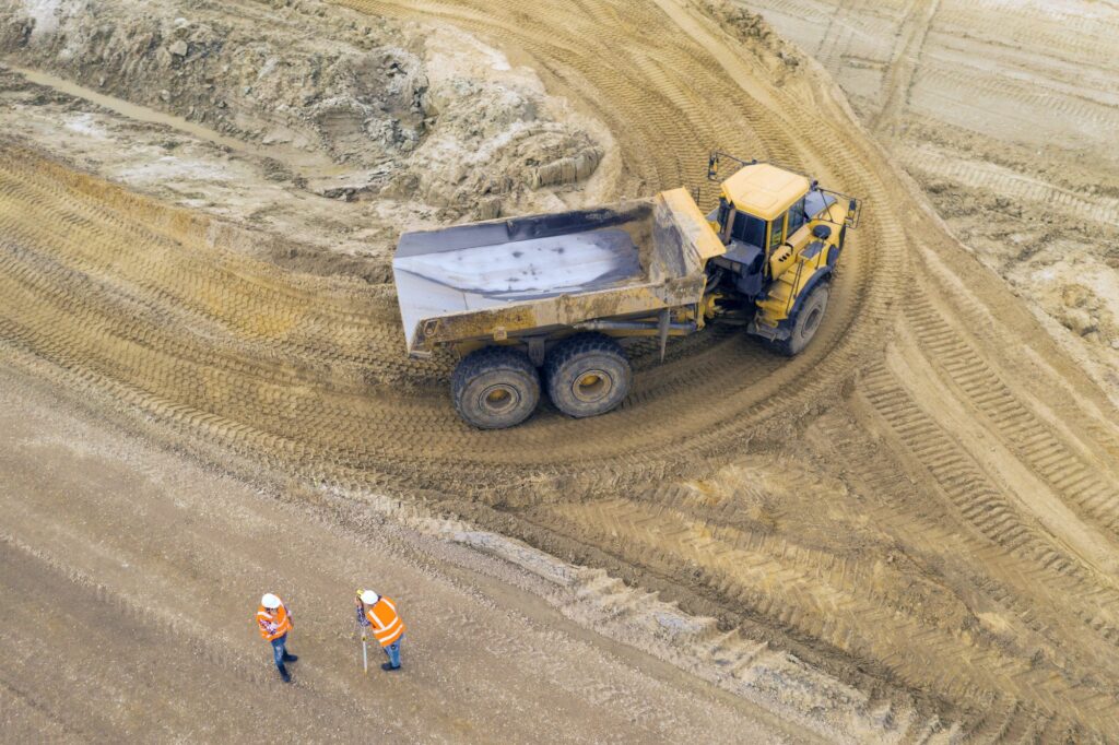 Big yellow excavator at a road construction site